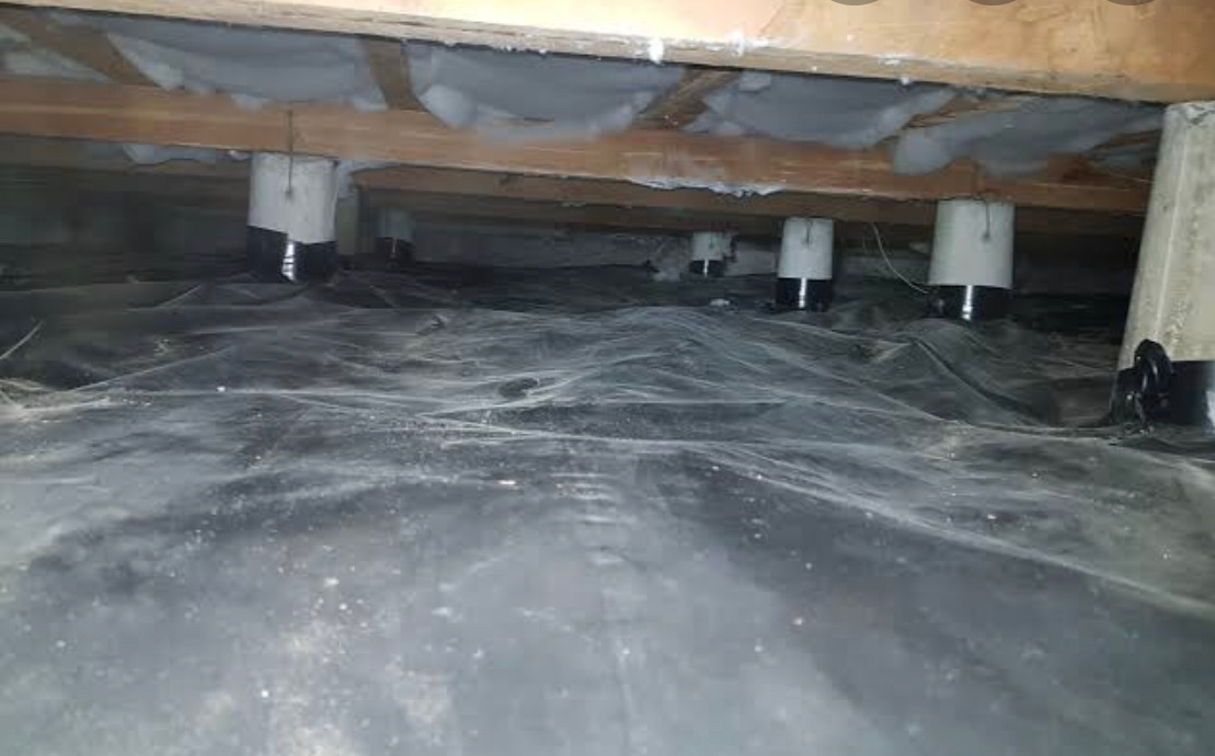 Moisture barrier sheeting sealed around subfloor piles and joists